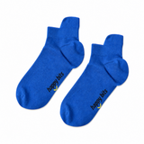 A pair of blue ankle bamboo socks on a plain white background, featuring the text 'happy bits' printed in black with a small yellow smiley face logo near the heel.